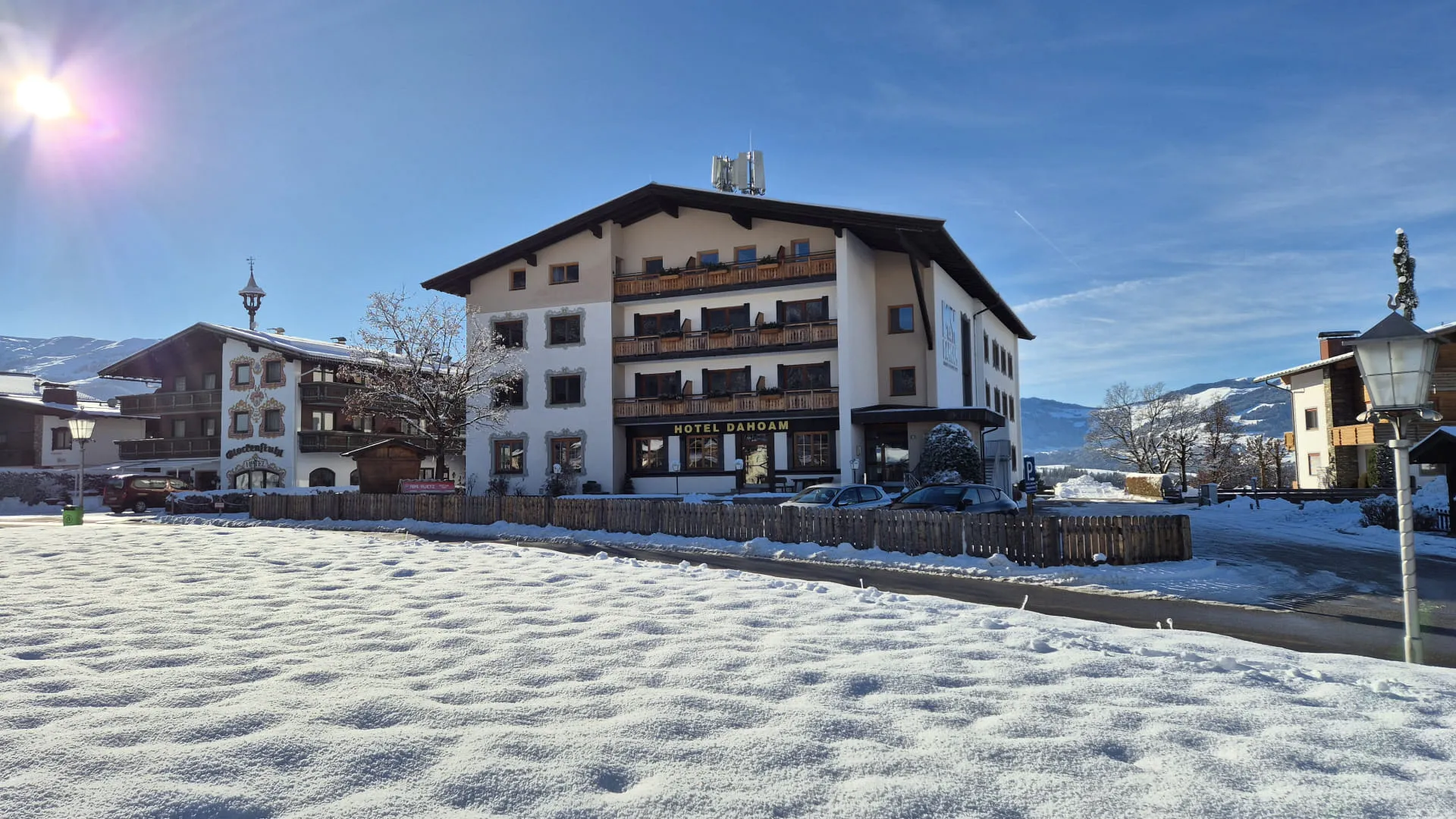 Hausansicht im Winter mit Schnee und blauem Himmel, Gebäude mit Balkonen