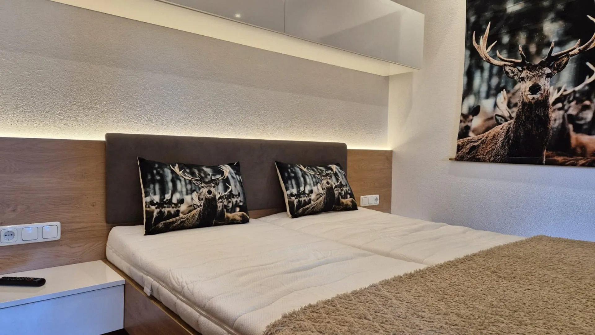 Ein Schlafzimmer mit einem Doppelbett, Kissen und dekorativen Bildern von Tieren.